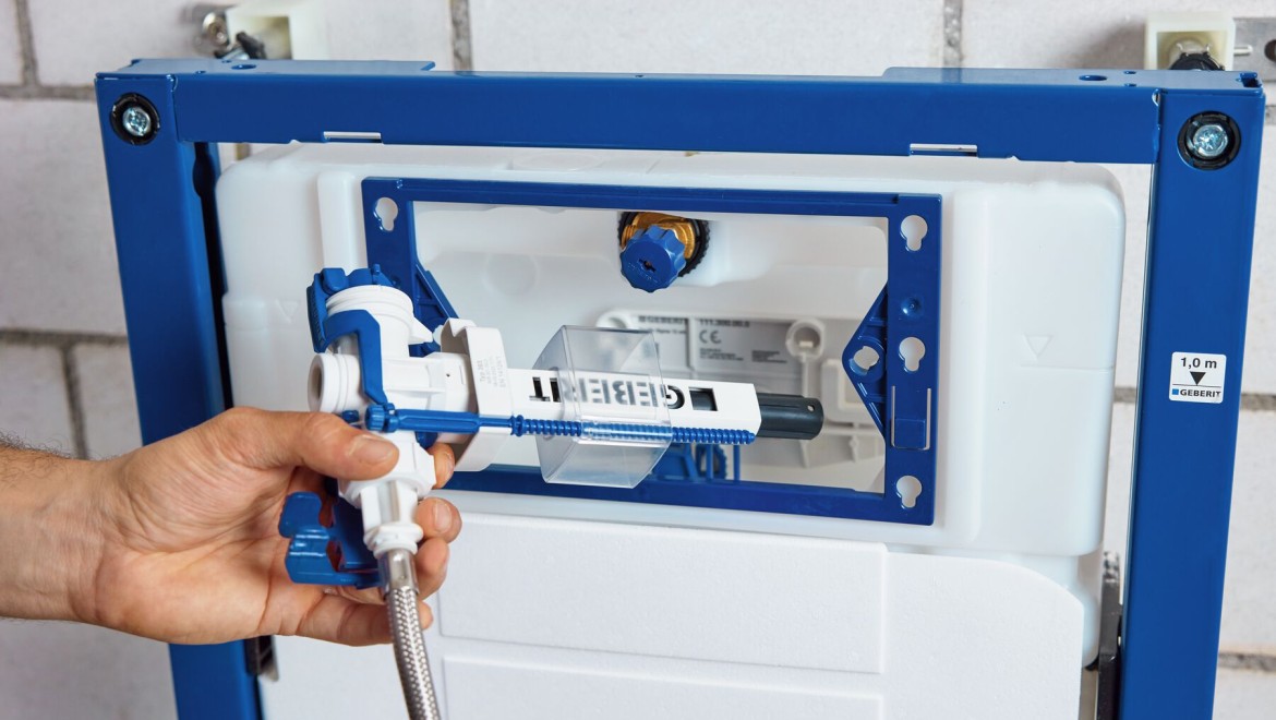 A plumber replacing the inlet valve of a Geberit cistern (© Geberit)