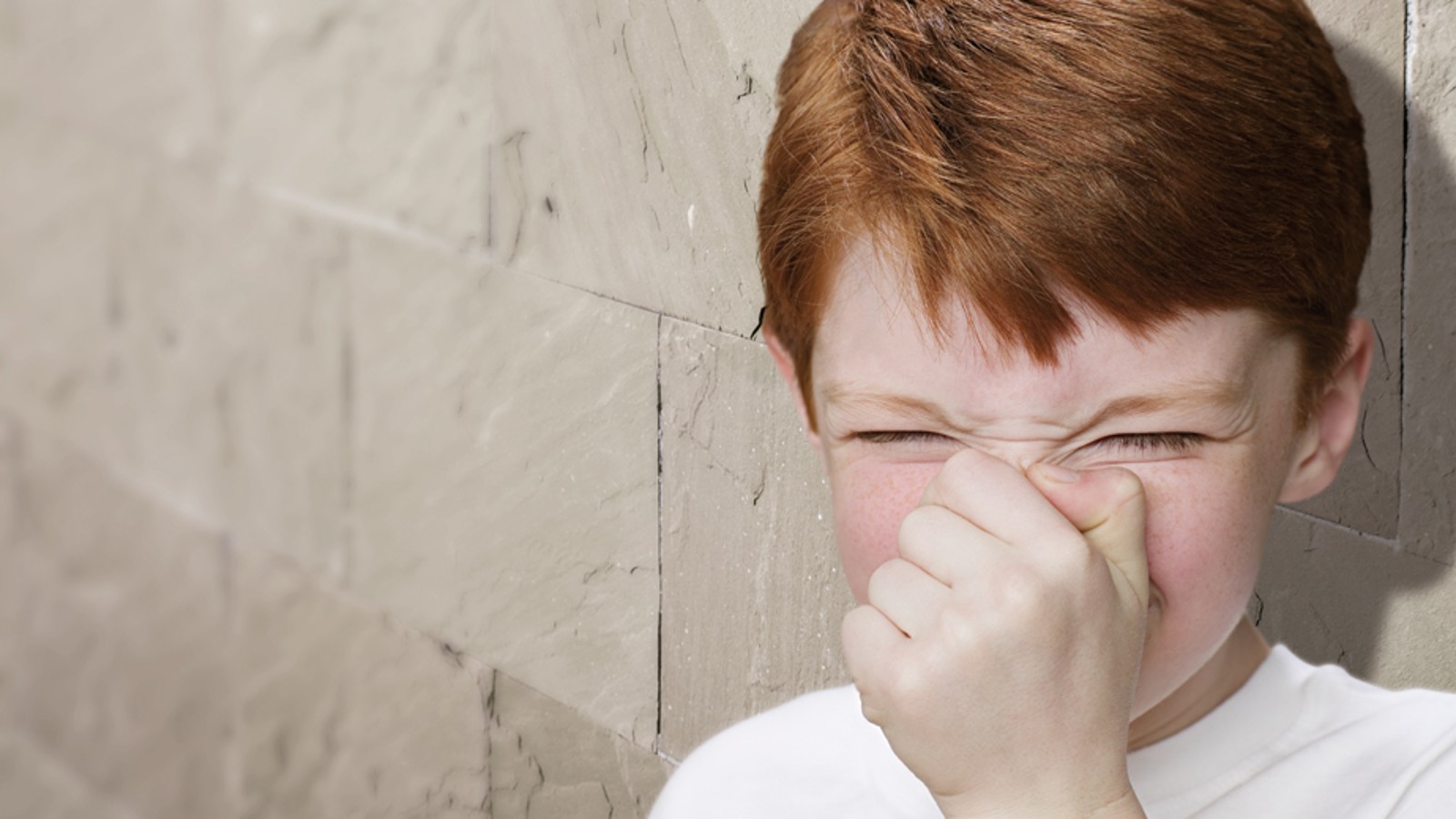 Boy holds his nose